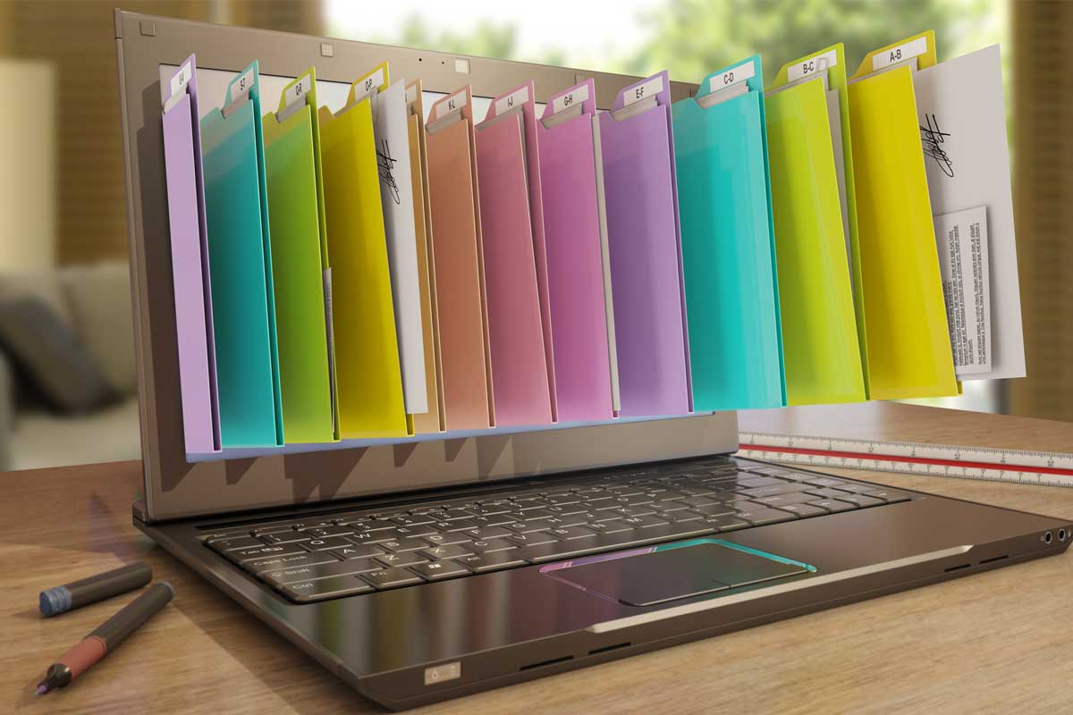 Photo of an open laptop with paper folders in multiple colors emerging from the screen