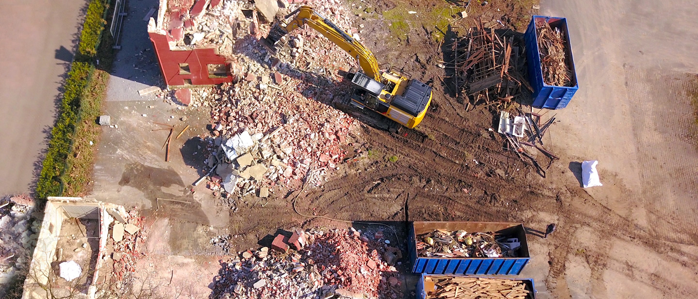 image of the demolition of a building with an excavator