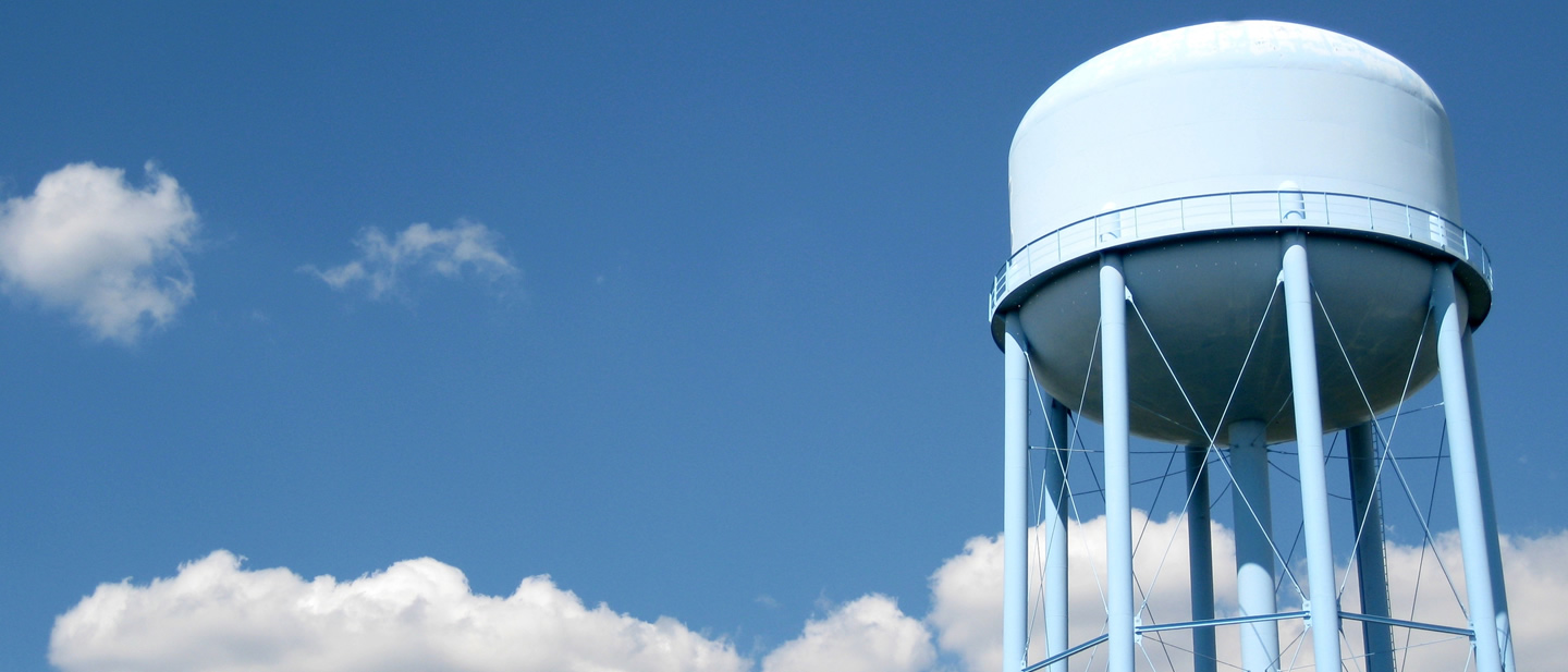 image of a municipal water tower against a blue sky background
