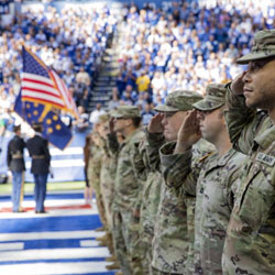 Indiana National Guardsmen salute the American flag at a Colts game in the 2022 season.