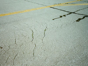 Overview photo showing a series of crescent-shaped cracks on the pavement surface.