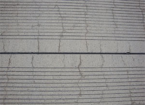 Close-up photo of a PCC joint with fine cracks perpendicular to the joint.           The cracks appear to be very tight with no visible signs of spalling.