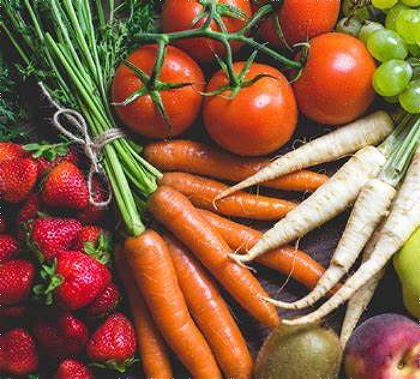 An assortment of colorful fresh fruits and vegetables, including strawberries, tomatoes, carrots and grapes.