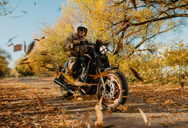 Female motorcycle trainee learning to weave between cones.