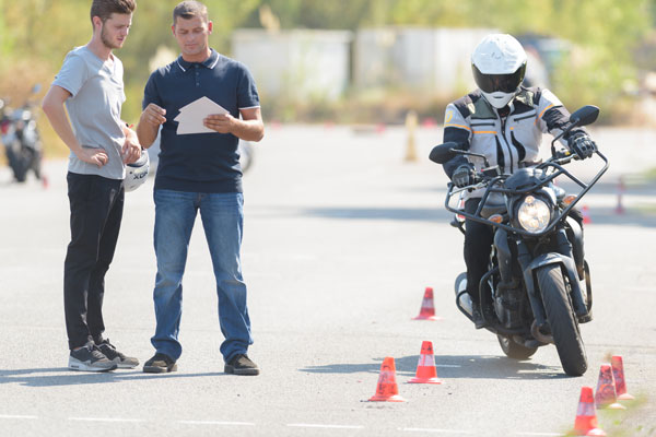 Motorcycle safety course instructor giving a student feedback.