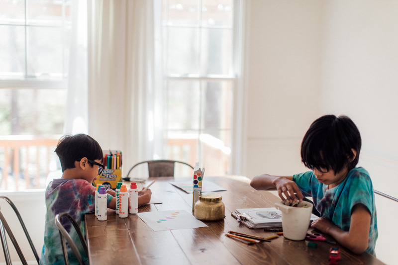 Kids doing artwork at kitchen table 